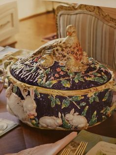 an elaborately decorated box sitting on top of a wooden table next to a chair