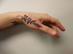 a person's hand with a small tattoo on the middle of their left arm