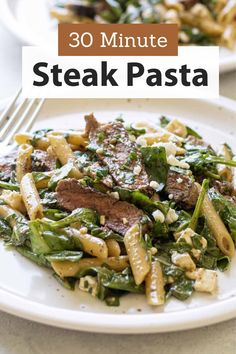 steak pasta with spinach and fettuccine on a white plate next to a fork