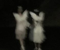 blurry photograph of two people dancing in the dark