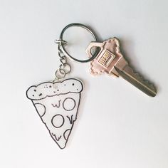 a slice of pizza keychain with a piece of pizza printed on the front