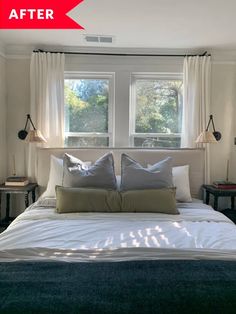 a bed sitting under two windows in a bedroom