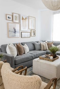 a living room filled with lots of furniture and pictures on the wall above it's windows