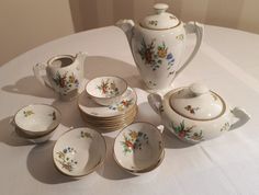 a white table topped with lots of dishes and cups