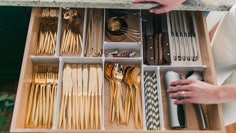 a drawer with utensils and spoons in it that is open to show the contents