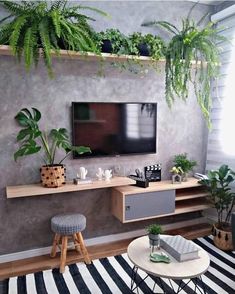 a living room filled with furniture and a flat screen tv mounted to the wall above it