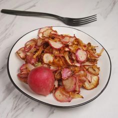 a white plate topped with sliced up radishes and an apple next to a fork