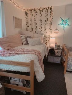 a bedroom with twin beds and string lights hanging from the ceiling above them is decorated with greenery