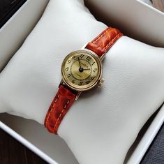 Vintage women's gilded small watch . The watch looks very elegant on a woman's wrist and goes well with other accessories. This watch perfectly captures the vintage style! The watch will be a great gift for lovers of vintage accessories. The watch is delivered in a beautiful box, so it is perfect as a gift. Peculiarities Brand Name: Chaika Made in USSR. Movement - mechanical. Case size - 18mm (0.7 inch) Strap:  eco-leather, length suitable for a wrist up to 18.5 cm (7.3 inches) Year of issue - 1980s Case: gilding Dial color - beige Condition - vintage, the watch is about 40 years old, but they are new, no one has worn them. . The clock works properly and shows the correct time. Serviced by a professional watchmaker. I will send the watch very quickly after purchase, as I am interested in y Yellow Gold Watch Gift, Timeless Watch With Gold Clasp As Gift, Yellow Gold Watch Accessories For Gift, Yellow Gold Watch Bracelet Strap, Elegant Gold Analog Watch Accessories, Elegant Watches With Gold Clasp For Gift, Elegant Watches With Gold Clasp As Gift, Classic Adjustable Gold Watches, Adjustable Gold Jewelry And Watches With Round Dial