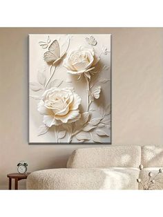 a living room with white furniture and flowers on the wall