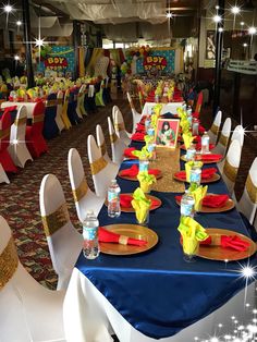 a banquet hall set up with blue and red table cloths