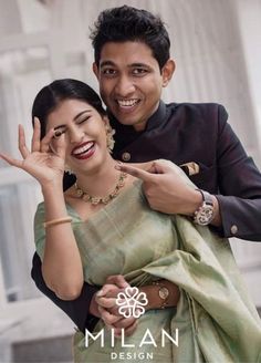 a man and woman posing for the camera with their hands up in front of them