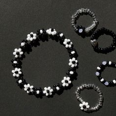 three pieces of beaded jewelry sitting on top of a black table next to each other