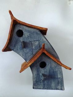 a blue birdhouse with two holes in the roof