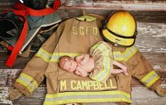 a fireman's uniform and hat are laying on the floor next to a baby