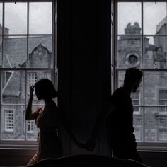 two people standing in front of a window