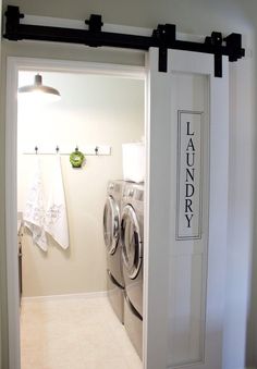 an open door leading to a washer and dryer in a room with white walls