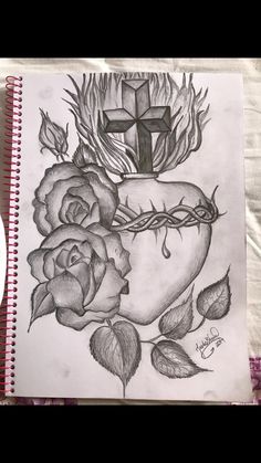 a drawing of roses and a cross on top of a book with writing underneath it