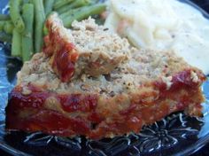 meatloaf, mashed potatoes and green beans on a blue plate with sauce