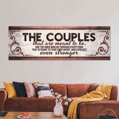 a living room filled with furniture and a large wooden sign above the couch that says, the couples that are meant to be