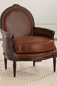 a brown leather chair sitting on top of a carpeted floor next to a white wall