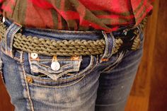 a person wearing jeans with a belt on their waist