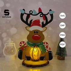 a lighted reindeer with a christmas hat and scarf sitting in front of a small tree