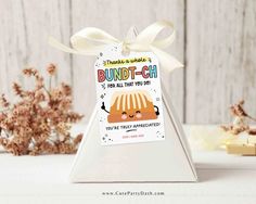 a white triangle shaped gift box with a label on it that says bundt - chi for all that you do