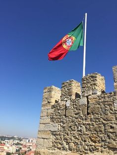 a flag flying on top of a stone castle