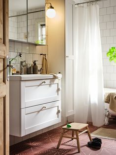 a bathroom with a stool, sink and mirror