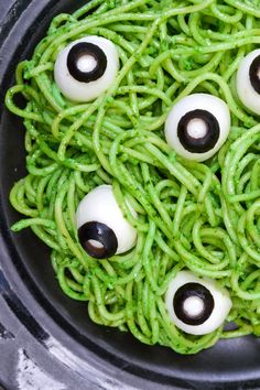 green noodles with googly eyes are ready to be cooked in the oven for halloween