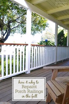 a wooden bench sitting on top of a porch next to a white fence and trees