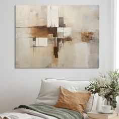 an abstract painting hangs on the wall above a bed with white sheets and throw pillows