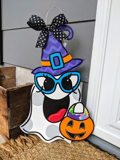 a halloween door hanger with a hat and sunglasses on it