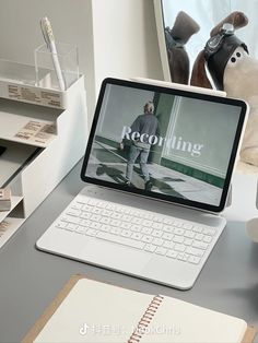 an open laptop computer sitting on top of a desk next to a pile of books