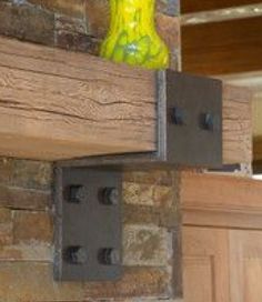 a yellow vase sitting on top of a wooden shelf in front of a brick wall