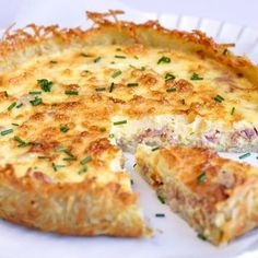 a cheesy quiche is cut into pieces on a plate