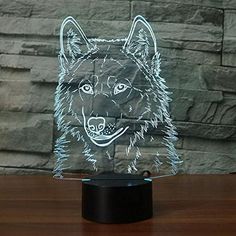 a glass sculpture of a wolf head on a wooden table next to a stone wall