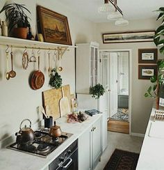 a kitchen with pots and pans hanging on the wall next to a stove top oven