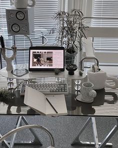 a desk with a computer, keyboard and various other items sitting on top of it