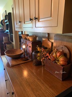 a kitchen counter with candles and pumpkins on the top, next to an old wooden box