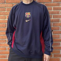 a man standing in front of a brick wall