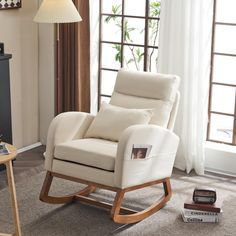 a white rocking chair sitting on top of a carpeted floor next to a window