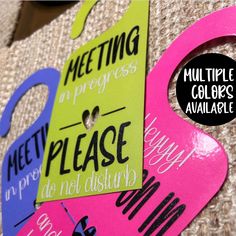 two pink and blue door hangers with words on them that say meeting in progress