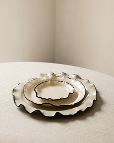 two plates sitting on top of a table next to each other in front of a white wall