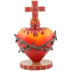 a red and orange vase with a cross on top