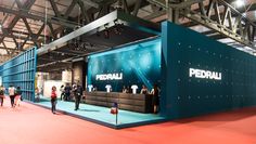 people are standing around in front of a large blue booth with the word pedrau on it