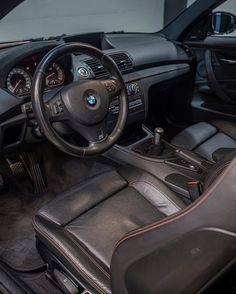 the interior of a car with black leather seats and steering wheel, dash board and dashboard