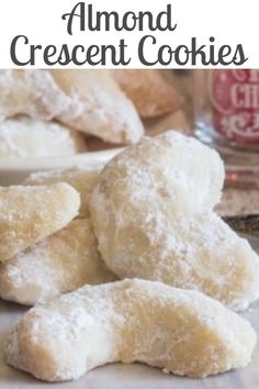 there are several cookies on the table with powdered sugar and other pastries in the background