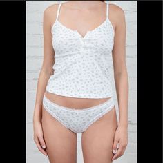 Soft Cotton Undies With An Elastic Lace Waistband With A Small Bow And A Floral Pattern. All Intimates Are Final Sale. Fabrics: 100% Cotton Measurement: 9.5" (24cm) Rise, 28" (71cm)Waist (Stretches) Made In: Europe White Delicate Strap Sleepwear For Spring, White Camisole With Delicate Straps For Loungewear, Daywear White Camisole, Bra-friendly, White Bra-friendly Camisole For Daywear, Bra Friendly White Camisole For Daywear, Bra-friendly White Camisole For Daywear, White Cami For Spring, White Seamless Camisole For Daywear, Brandy Melville Undies